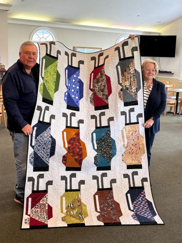 1.Kingswood Gold Club members, Sabastian Tordonato and Mary Morgan, display quilt made by Mary Morgan for Sabastian as a &ldquo;thank you&rdquo; for assisting Ladies of the Lakes Quilters&rsquo; Guild&rdquo; (a 501(c ) 3) in preventing the demolition of the Old Firehouse Wolfeboro Community Center and supporting its restoration.